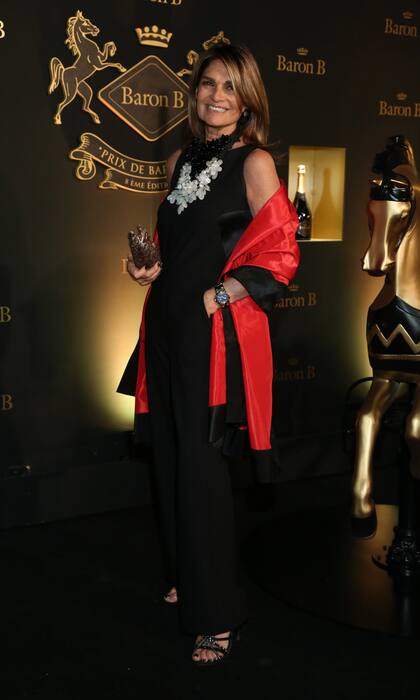 Teresa Calandra combinó un mono negro con un floreado collar XL y chal de raso colorado