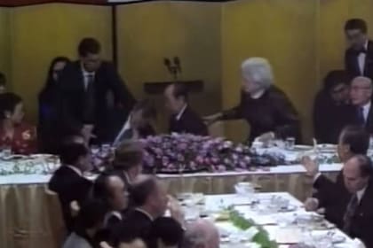 George HW Bush desmaia num jantar de gala no Japão, o que preocupa o primeiro-ministro japonês Kiichi Miyazawa e a primeira-dama americana Barbara Bush.