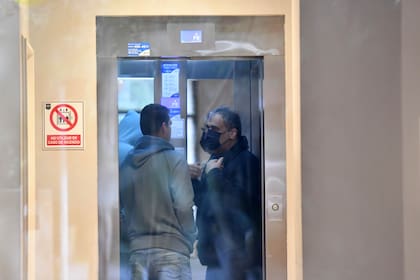 Gholamreza Ghasemi (de barbijo negro) en el ascensor del Hotel Plaza Central Canning, junto a dos compañeros de tripulación