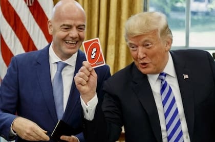Gianni Infantino en la Casa Blanca junto a Donald Trump, que sostiene una carta carta de reversa en sus manos