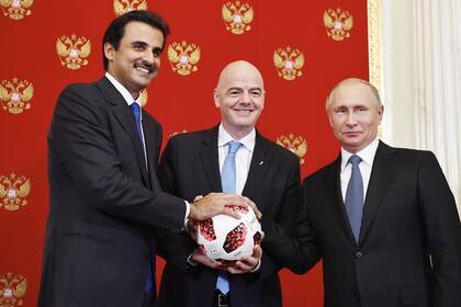 Gianni Infantino, presidente de la FIFA, con Vladimir Putin (presidente ruso) y Tamim bin Hamad al-Thani (emir de Qatar), en 2018