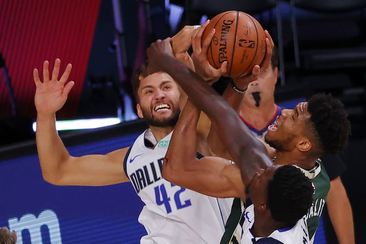 Giannis Antetokounmpo # 34 de los Milwaukee Bucks recibe una falta de Maxi Kleber # 42 de los Dallas Mavericks mientras Dorian Finney-Smith # 10 defiende en The Arena en ESPN Wide World Of Sports Complex el 08 de agosto de 2020 en Lake Buena Vista, Florida .