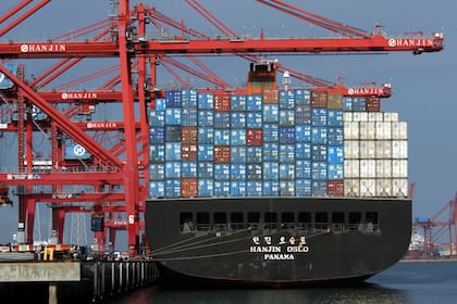 Gigantescas grúas en Hanjin Shipping cargan contenedores de envío de 30 toneladas en el carguero Hanjin Oslo en el Puerto de Los Ángeles el 29 de marzo en Los Ángeles, CA. Las grúas actuales, con un promedio de 100 pies de altura con plumas de 137 pies de largo, pronto se actualizarán a 240 pies de altura con plumas de 210 pies de largo. Para fin de año, el puerto más activo de la nación se volverá "supergrande" con grúas, cargueros y remolcadores cada vez más masivos para satisfacer el insaciable apetito estadounidense por productos importados baratos. (Foto por
David McNew/Getty403123 06: Gigantic cranes at Hanjin Shipping load 30-ton shipping containers onto the Hanjin Oslo freighter in the Port of Los Angeles March 29 in Los Angeles, CA. Current cranes, averaging 100 feet tall with 137 foot long booms, will soon be upgraded to 240 feet tall with 210 foot long booms. By the end of the year, the nation's busiest port will become "super-sized" with ever more massive cranes, freighters, and tug boats to meet the insatiable American appetite for cheap imported goods. (Photo by David McNew/Getty Images)