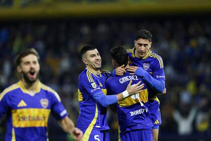 Giménez, abrazado por sus compañeros, luego de haberle dado la clasificación a Boca tras anotar su penal