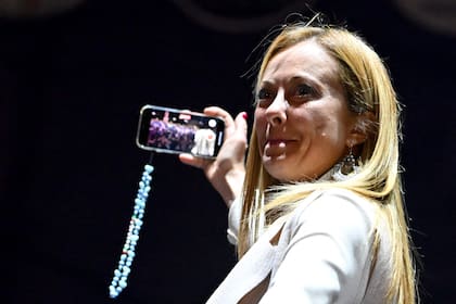 Giorgia Meloni hace un video selfie tras su discurso en el cierre de campaña en la Piazza del Popolo, en Roma. (Alberto PIZZOLI / AFP)
