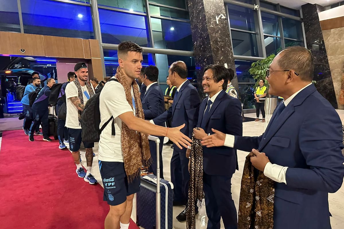 Giovani Lo Celso estrecha la mano de dirigentes indonesios en la llegada de la selección argentina a Yakarta, donde el lunes jugará un partido amistoso con la selección local