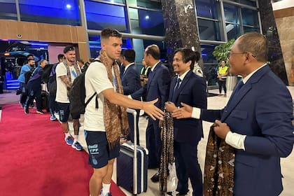 Giovani Lo Celso estrecha la mano de dirigentes indonesios en la llegada de la selección argentina a Yakarta, donde el lunes jugará un partido amistoso con la selección local