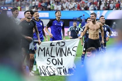 Giovani Lo Celso y Cristian Romero sostienen la bandera; la FIFA analiza posibles sanciones, que en principio serían solo económicas
