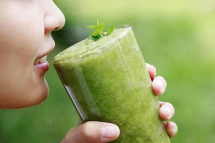 Girl hold green celery juice in glass with measuring tape in healthy drinking concept. alternative food and drink with organic ingredient for good living lifestyle