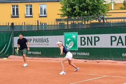 Gisela Dulko, en plena práctica; a la izquierda, Rodolfo Daruich, que las asiste en la preparación