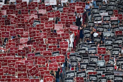 GLENDALE, ARIZONA - SEPTEMBER 21: Attendees hold up signs at the memorial service for political activist Charlie Kirk at State Farm Stadium on September 21, 2025 in Glendale, Arizona. Kirk, the CEO and co-founder of Turning Point USA, was shot and killed on September 10th while speaking at an event during his "American Comeback Tour" at Utah Valley University. Eric Thayer/Getty Images/AFP (Photo by Eric Thayer / GETTY IMAGES NORTH AMERICA / Getty Images via AFP)