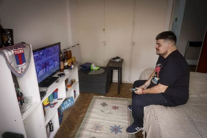 Gonzalo frente al televisor, en su departamento de San Fernando