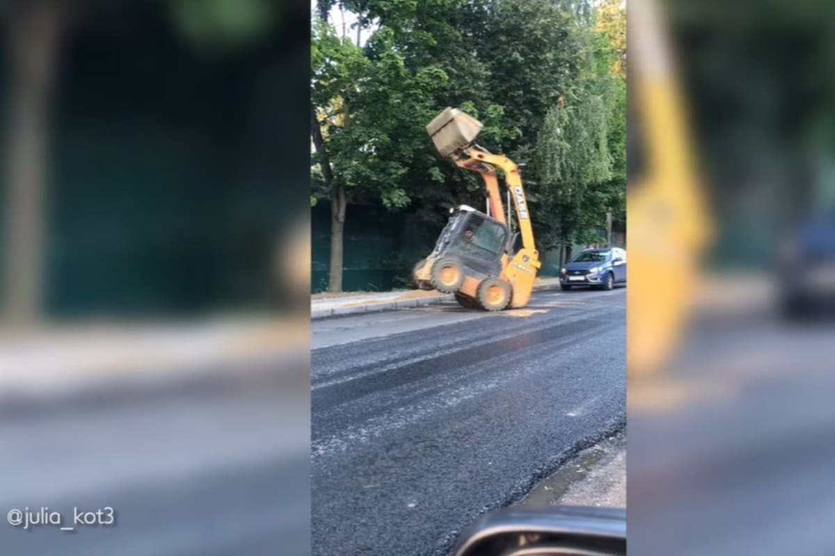Graban a una máquina excavadora haciendo piruetas en mitad de la ruta