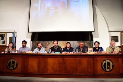 Grabois y el obispo Carrara, junto a un panel de dirigentes sociales en la CGT