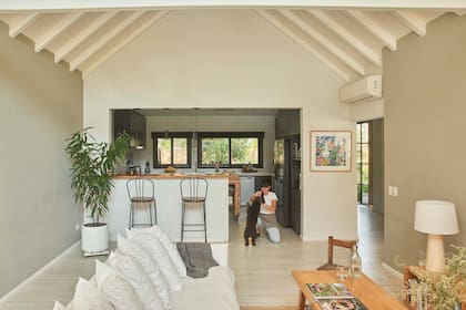 Gracias a la apertura hacia el living, con barra, la cocina ganó mucha luz natural. Las lajas negras dejaron paso al piso 'Ecowood Puro' (ILVA).