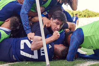 Gran foto del festejo del gol de Barticciotto, con el DT Medina metido en la montaña humana del festejo: Talleres dio el golpe en La Plata