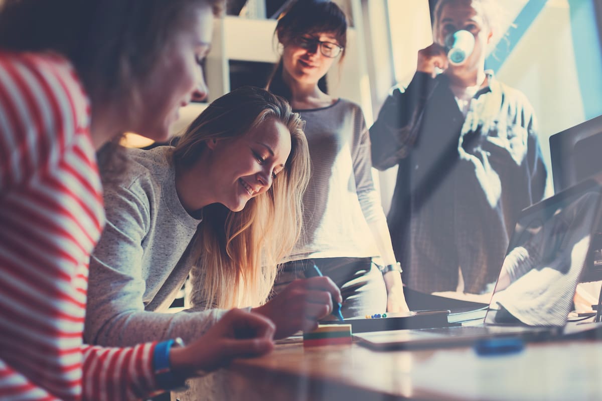 Group of young business people working together in big coworking office. Marketing department discussing product plan. New startup company. Windows reflection effect