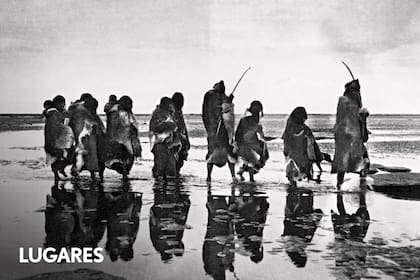 Grupo selk’nam camina por la playa, cerca del río Fuego, Río Grande. 1908.