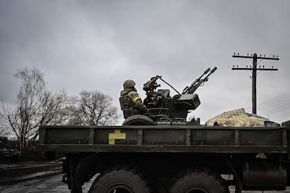 Un soldado ucraniano vigila los cielos con un arma antiaérea en las afueras de Kiev, a la espera de los aviones rusos