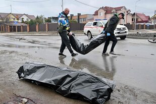 Trabajadores comunales llevan bolsas para cadáveres en la ciudad de Bucha, no lejos de la capital ucraniana de Kiev, el 3 de abril de 2022