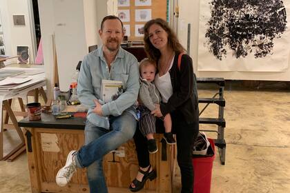 Guillermo Kuitca en su estudio con los dos nuevos libros de Zacharías; entre el artista y ella, el hijo de la autora