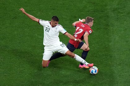 Guillermo Martínez (22) disputa la pelota con Lukas Cerv en el áspero partido entre México y República Checa, por la tercera fecha del grupo A