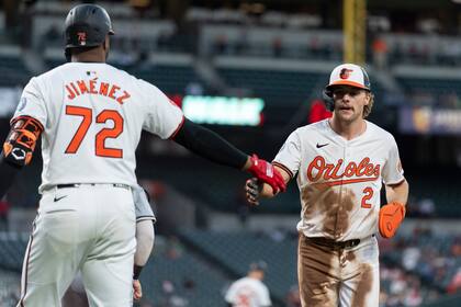 Gunnar Henderson, de los Orioles de Baltimore, festeja con su compañero, el dominicano Eloy Jiménez, luego de anotar en una base por bolas ante los Medias Blancas de Chicago, el martes 3 de septiembre de 2024 (AP Foto/Stephanie Scarbrough)