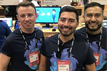 Gustavo, en el medio, justo a sus amigos y socios en una muestra sobre la aplicación en una feria de tecnología