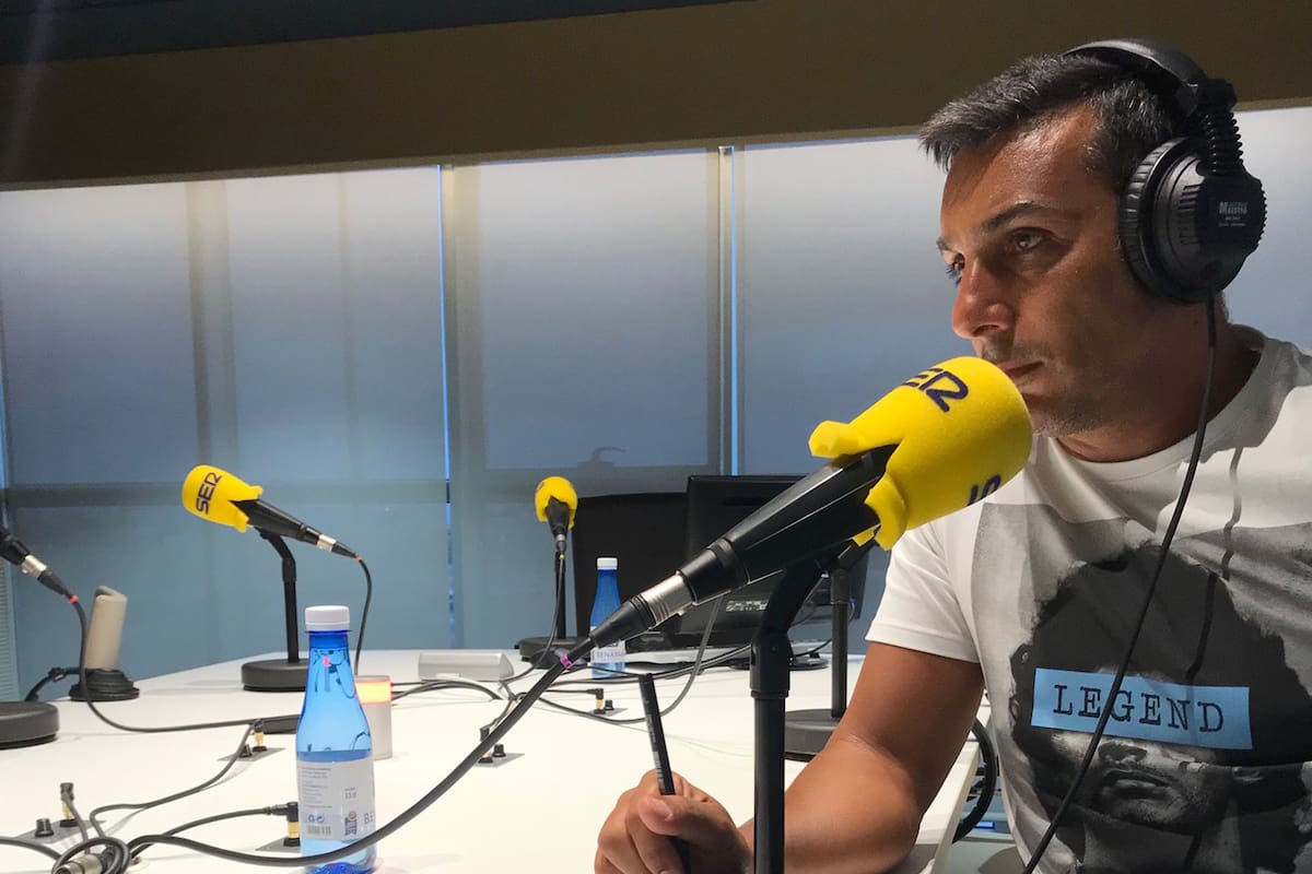 Gustavo López en la función de comentarista, televisivo y radial, un sello que se instaló en España; en la remera, un homenaje a Maradona