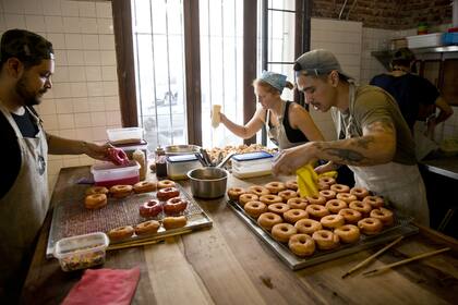 Gustavo y sus colaboradores preparan las donas