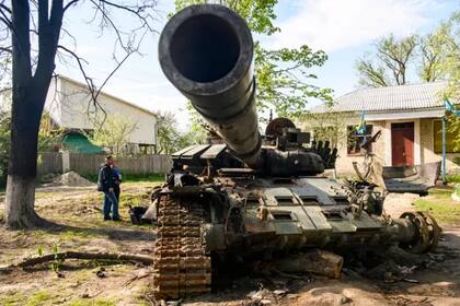 Habitantes locales junto a un tanque ruso destruido en Sloboda, en la ciudad de Chernígov, en el norte de Ucrania en mayo.