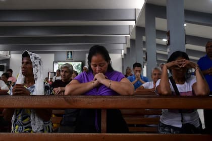 Habitantes locales oran durante una misa con motivo del Día Nacional de Oración por las víctimas del terremoto en Valencia, estado Carabobo, Venezuela