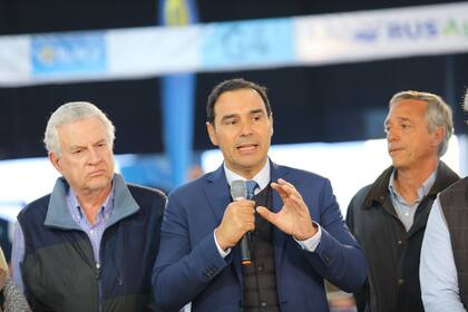 Habla el gobernador de Corrientes Gustavo Valdés. Lo acompañan, a la izquierda, Daniel Werthein (en representación de la Sociedad Rural Argentina) y a la derecha Federico Palma (Sociedad Rural de Corrientes)
