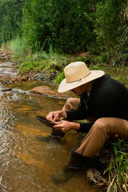 Turistas y gente de la zona practica la tradición de buscar pepitas de oro en el río.
