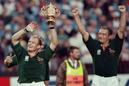 Hannes Strydom junto al capitán de los Springboks François Pienaar en los festejos por el campeonato del mundo de Sudáfrica en 1995; el segunda línea murió a sus 58 años