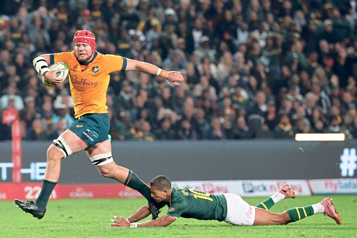 Harry Wilson corre con la pelota y marcará un try para Australia, pese al intento de Manie Libbok por detenerlo; fue la jugada en la que los Wallabies pasaron al frente en el marcador