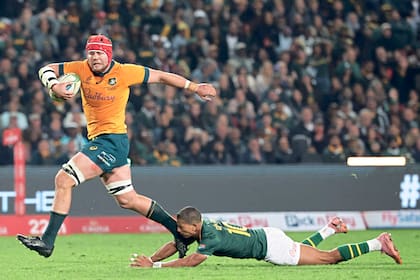 Harry Wilson corre con la pelota y marcará un try para Australia, pese al intento de Manie Libbok por detenerlo; fue la jugada en la que los Wallabies pasaron al frente en el marcador
