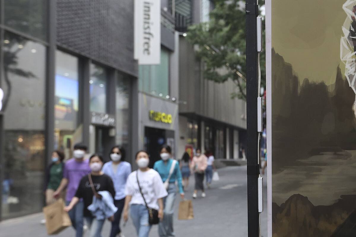 Hasta la Mona Lisa en un afiche publicitario de una peluquería usa barbijo en las calles de Seúl, Corea del Sur