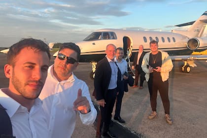 Hayden Davis, de campera color crema, antes de subir a un jet durante su visita a la Argentina