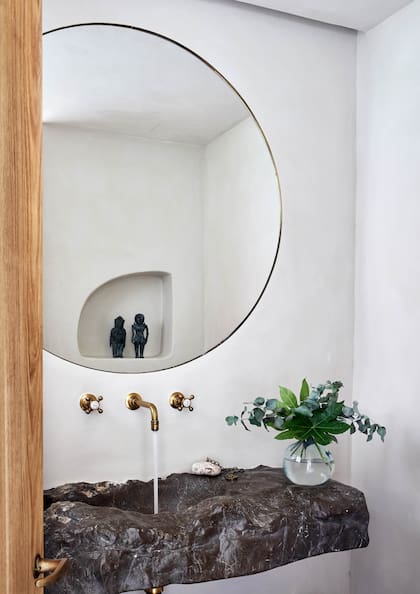 Hecha en una pieza de la misma cuarcita vista en el baño y el living, pero esta vez sin pulir, la bacha se inscribe en la síntesis de materiales, colores y elementos.