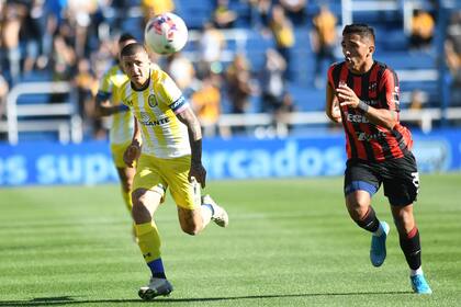Héctor Canteros, de Central, intenta llegar a la pelota antes que su marcador, Rolando García.
