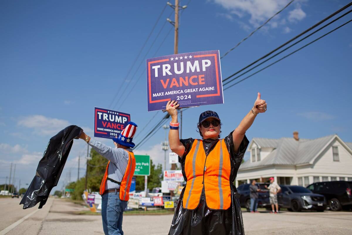 Héctor y Raquel Ramírez muestran su apoyo a Donald Trump frente a un colegio electoral en Cypress, Texas, el 5 de noviembre