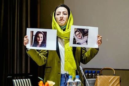 Heda Khamoush, delegada de la sociedad civil afgana, exhibe fotos de mujeres desaparecidas