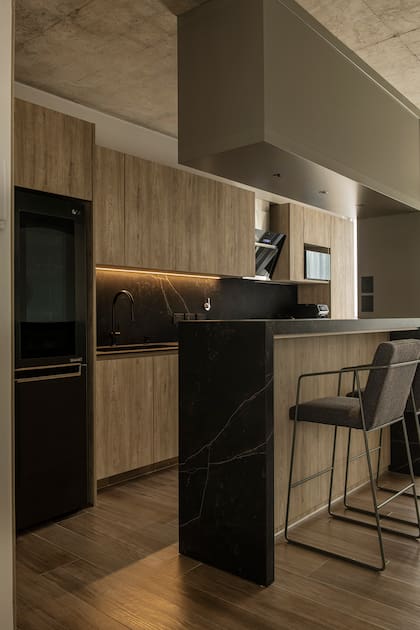 Heladera negra (LG), para mantener todo dentro de la gama. Banquetas (Solsken). Piso de porcelanato símil madera de Ilva (SBG)