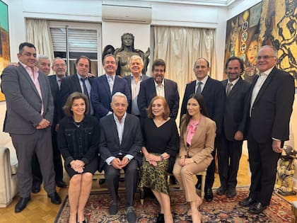 Helen Ferrer, sentada a la izquierda de Álvao Uribe, y Carlos Díaz Rosillo, de pie detrás del expresidente, en el centro de la imagen que dejó la cena de María Cristina Guzmán