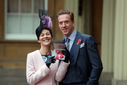 Helen McCrory y su esposo Damian Lewis en el palacio de  Buckingham cuando fue condecorada por la reina por su contribución a las artes escénicas