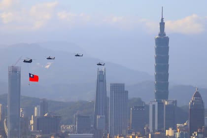 Helicópteros taiwaneses exhiben una enorme bandera de su país sobre el cielo de Taipei