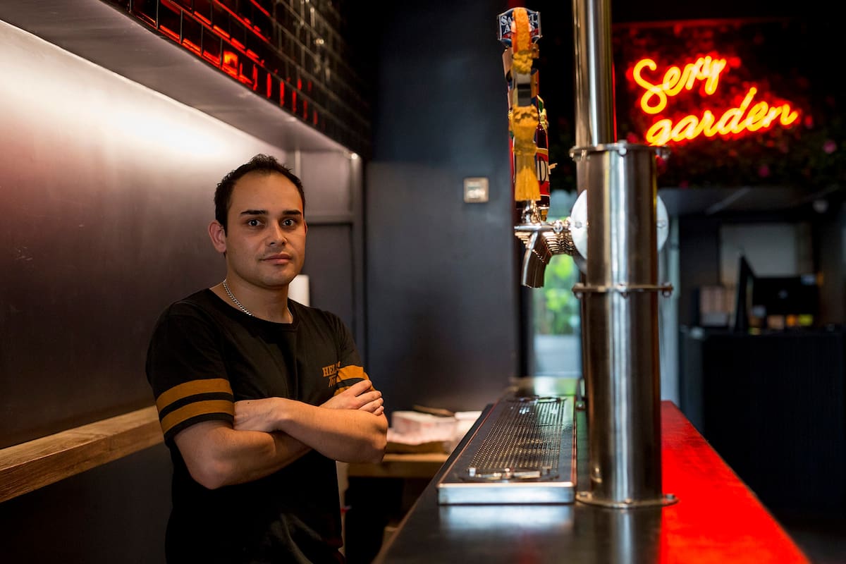 Henry Barrera, 29, de Bogota, Colombia, inmigro a Argentina hace 6 años. Hoy es la cara sonriente detrás de la barra de Hell''s, la pizzería de culto que abrió hace tres meses en Palermo.