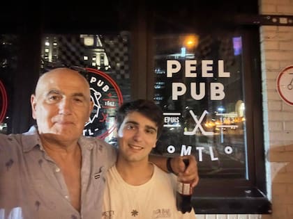 Hernán junto a su hijo, frente al bar donde trabajó en su juventud.