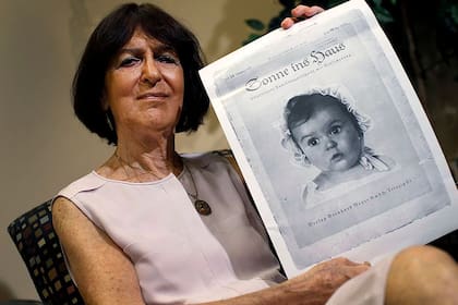 Hessy Levinsons Taft, junto a la icónica portada de la revista nazi Sonne ins Haus de 1935, tras su elección como la bebé aria más hermosa